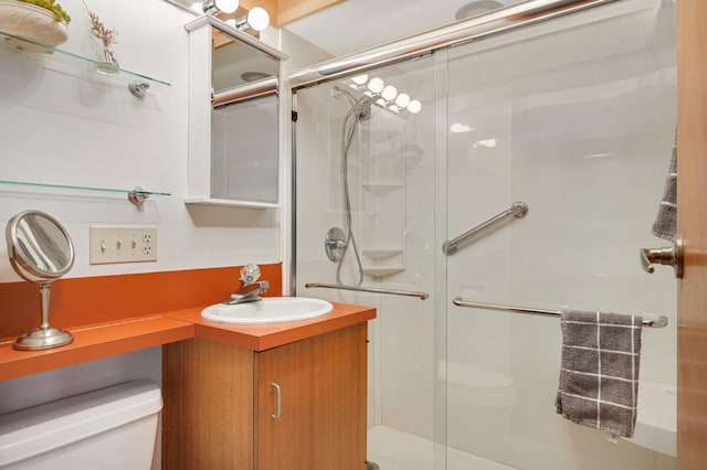 bathroom featuring a stall shower, vanity, and toilet