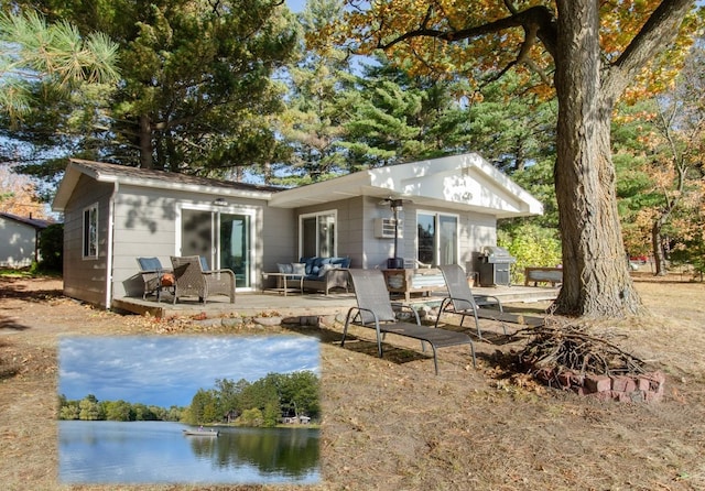 back of property with a patio area and a water view