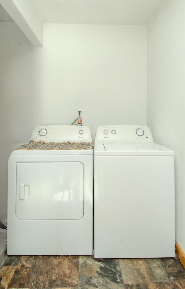 laundry area featuring laundry area, washing machine and dryer, and stone finish flooring