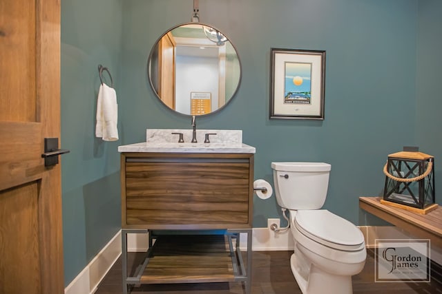 bathroom featuring wood-type flooring, vanity, and toilet