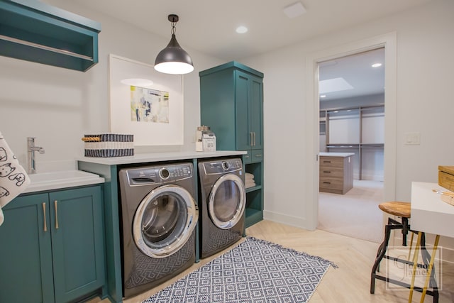 laundry area featuring cabinets, sink, and washer and dryer