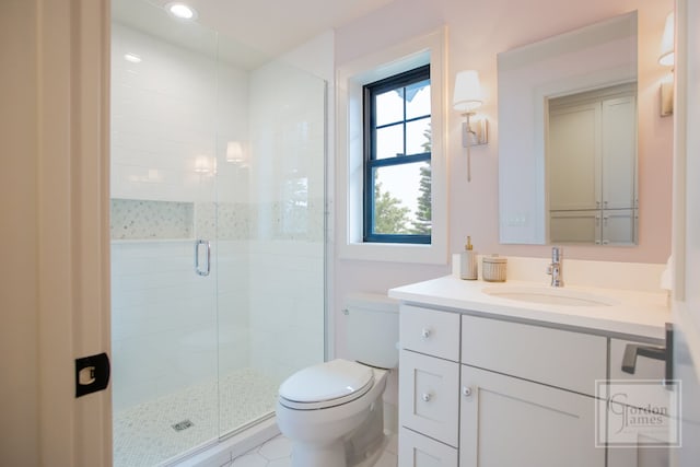 bathroom featuring vanity, toilet, and an enclosed shower