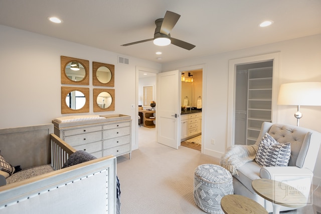 carpeted bedroom featuring ceiling fan, a closet, a walk in closet, and ensuite bath