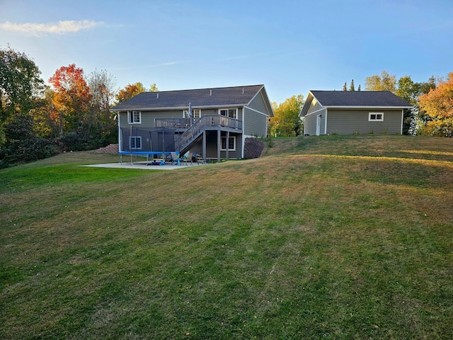 rear view of property with a deck, a patio, and a lawn