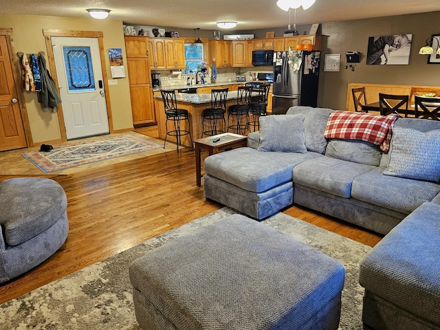 living room featuring a textured ceiling and light hardwood / wood-style floors