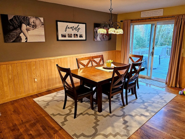 dining room with hardwood / wood-style floors and an inviting chandelier