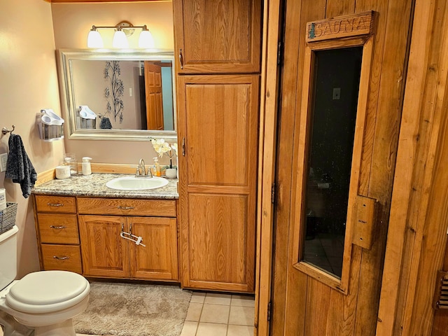 bathroom featuring vanity, tile patterned flooring, and toilet