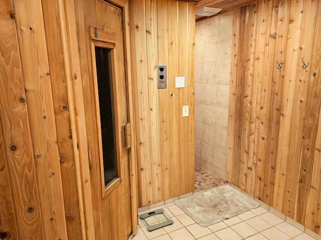 interior space featuring light tile patterned flooring and wooden walls