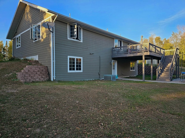 rear view of property featuring a wooden deck, a lawn, and central air condition unit