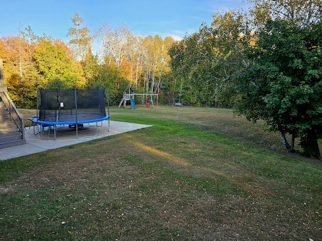 view of yard featuring a playground and a trampoline