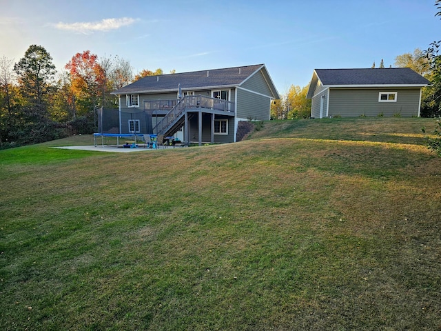 rear view of house with a deck and a lawn