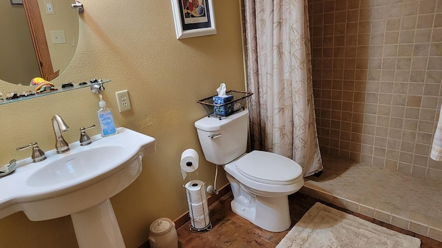 bathroom featuring toilet, sink, and a shower with shower curtain