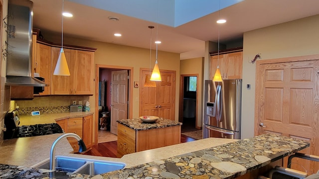 kitchen featuring a kitchen island, range, hanging light fixtures, light hardwood / wood-style flooring, and stainless steel refrigerator with ice dispenser