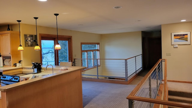 kitchen featuring light brown cabinetry, sink, decorative light fixtures, and dark colored carpet