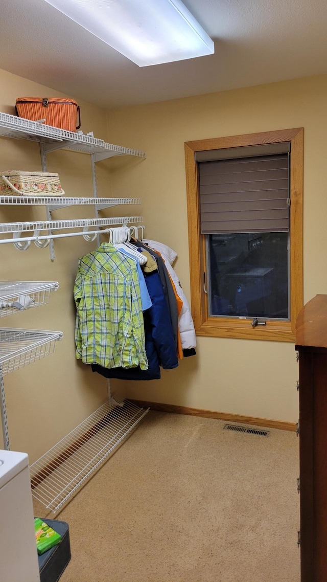 walk in closet featuring carpet flooring