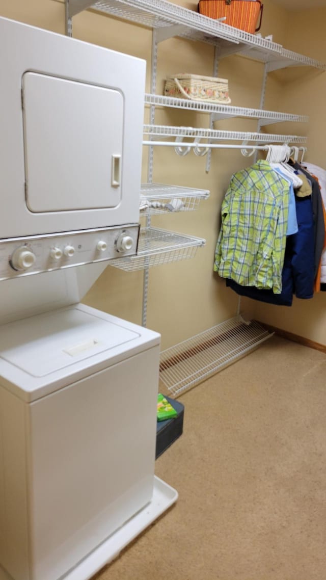 laundry area with carpet flooring and stacked washing maching and dryer