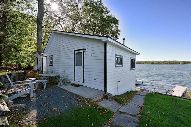 view of property exterior featuring a patio and a water view