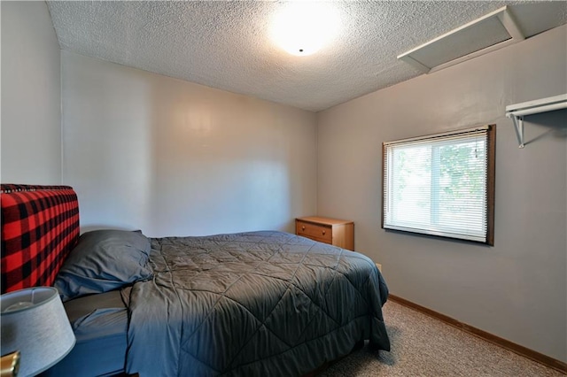 carpeted bedroom featuring a textured ceiling, baseboards, and attic access