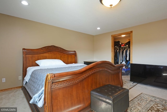 carpeted bedroom featuring a closet and a walk in closet