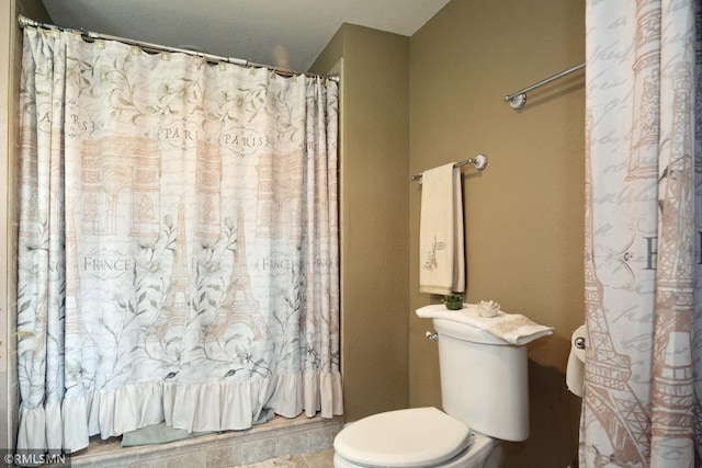 bathroom with toilet and a shower with curtain