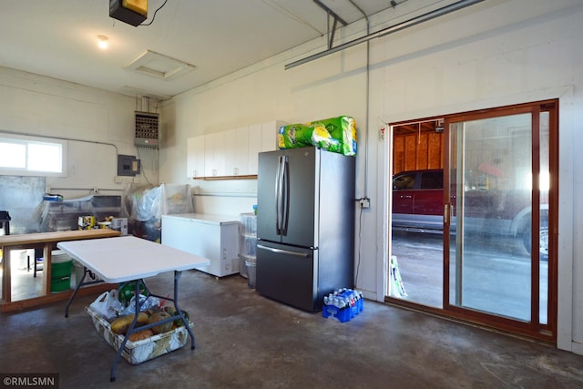 garage with a garage door opener, fridge, and stainless steel refrigerator