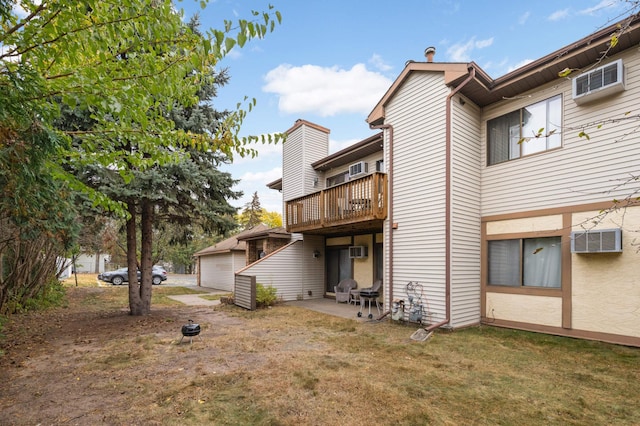 back of house featuring a lawn, a patio area, and a wall mounted AC