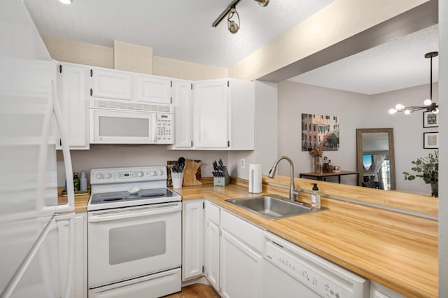 kitchen with pendant lighting, white cabinetry, white appliances, and sink