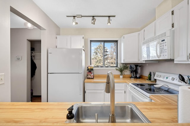 kitchen with white cabinetry, sink, rail lighting, wood counters, and white appliances