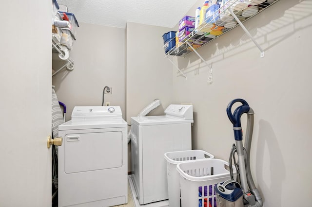 clothes washing area featuring a textured ceiling and washing machine and dryer