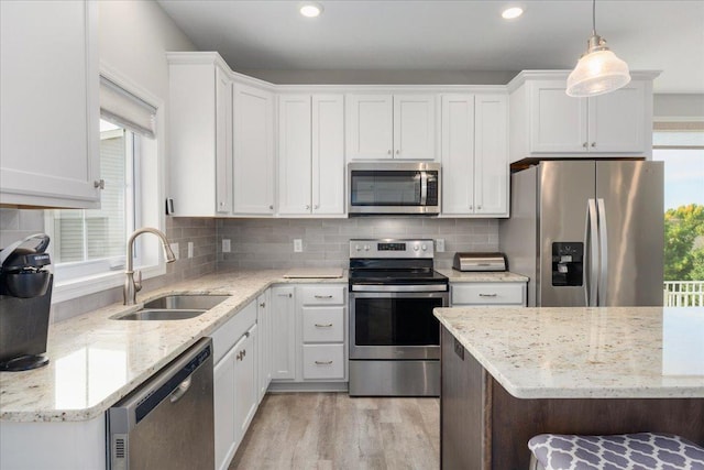 kitchen featuring white cabinets, stainless steel appliances, sink, and a healthy amount of sunlight