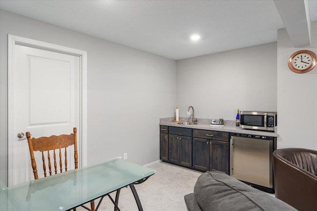 kitchen featuring dark brown cabinets, light colored carpet, stainless steel appliances, and sink