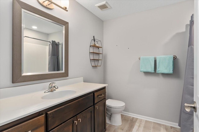 bathroom with toilet, hardwood / wood-style floors, a shower with shower curtain, vanity, and a textured ceiling