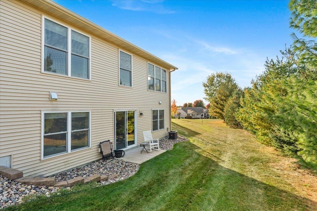 back of property featuring a lawn, a patio area, and central AC