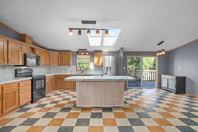 kitchen with a wealth of natural light, pendant lighting, a kitchen island, and black appliances