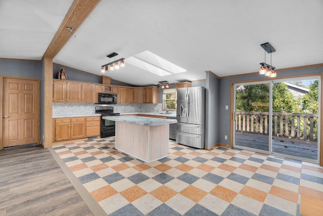 kitchen featuring pendant lighting, black appliances, vaulted ceiling with skylight, decorative backsplash, and a kitchen island