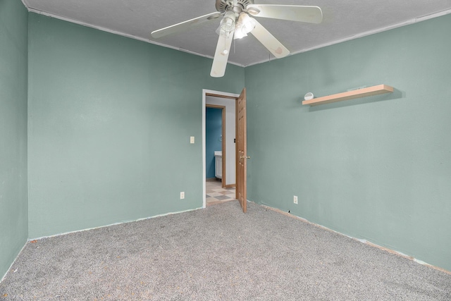 spare room featuring carpet, ceiling fan, and crown molding