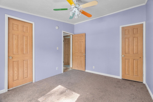 unfurnished bedroom featuring carpet flooring, ceiling fan, and crown molding