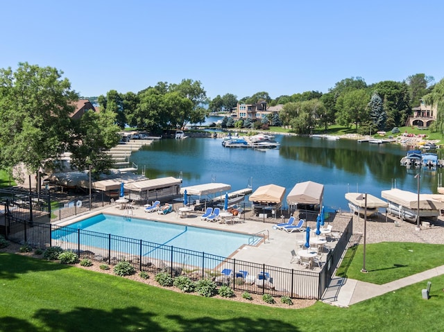 view of swimming pool with a water view, a lawn, and a patio area