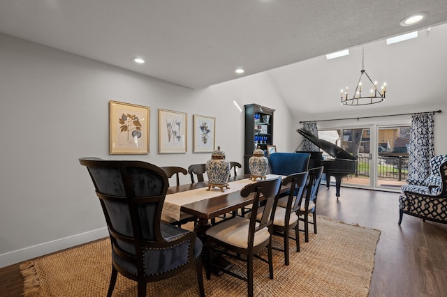 dining area featuring a notable chandelier, lofted ceiling, and hardwood / wood-style floors