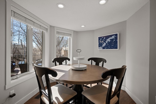 dining area with a textured ceiling and dark wood-type flooring