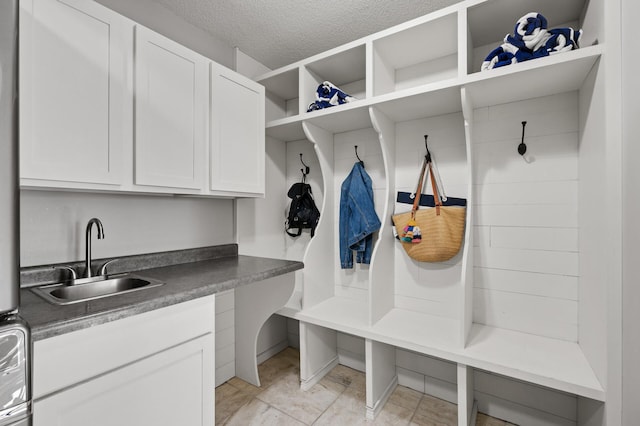 mudroom with a textured ceiling and sink