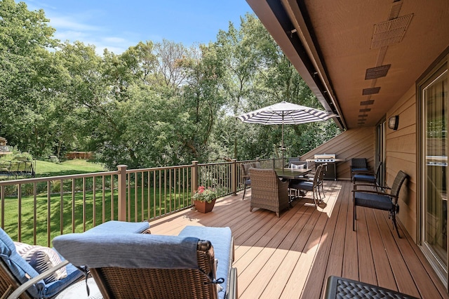 wooden terrace featuring a lawn