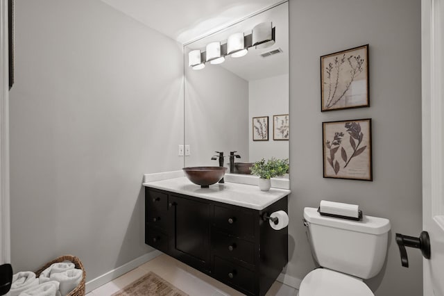 bathroom featuring vanity, tile patterned flooring, and toilet