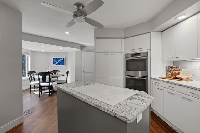 kitchen with dark hardwood / wood-style flooring, white electric cooktop, and white cabinets