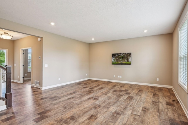 empty room with hardwood / wood-style flooring and a textured ceiling