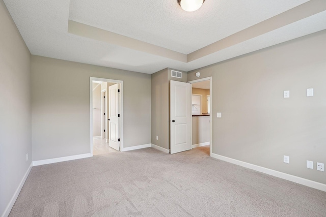 unfurnished bedroom with light colored carpet and a textured ceiling