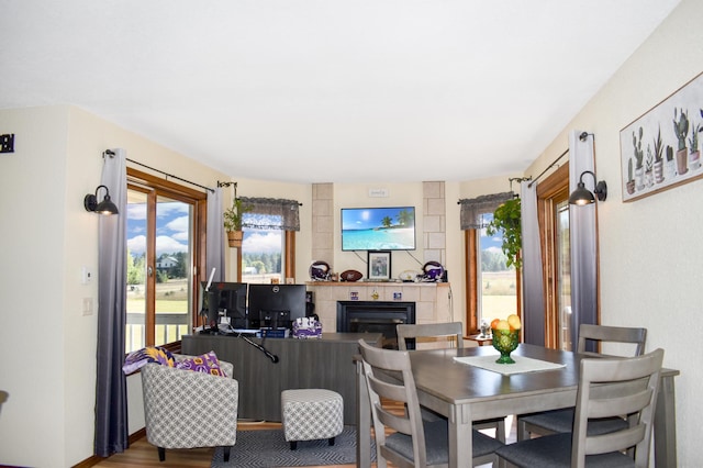 dining space with a tiled fireplace and hardwood / wood-style flooring