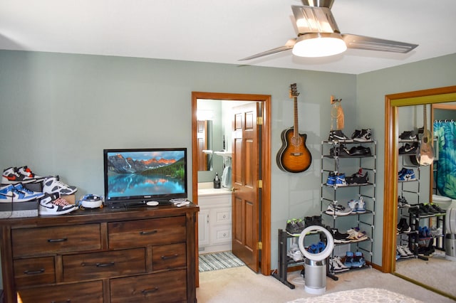 bedroom with ensuite bath, light carpet, and ceiling fan
