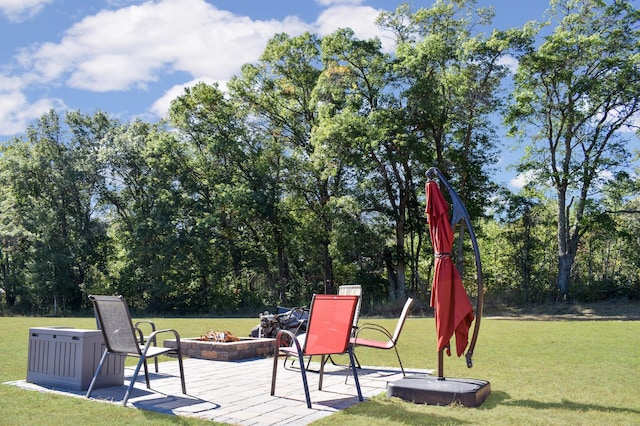 exterior space featuring a patio, a lawn, and a fire pit