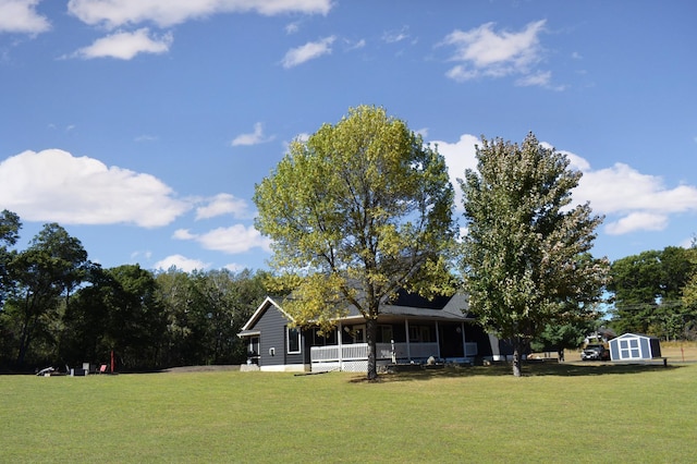 view of yard with a shed, covered porch, and an outdoor structure